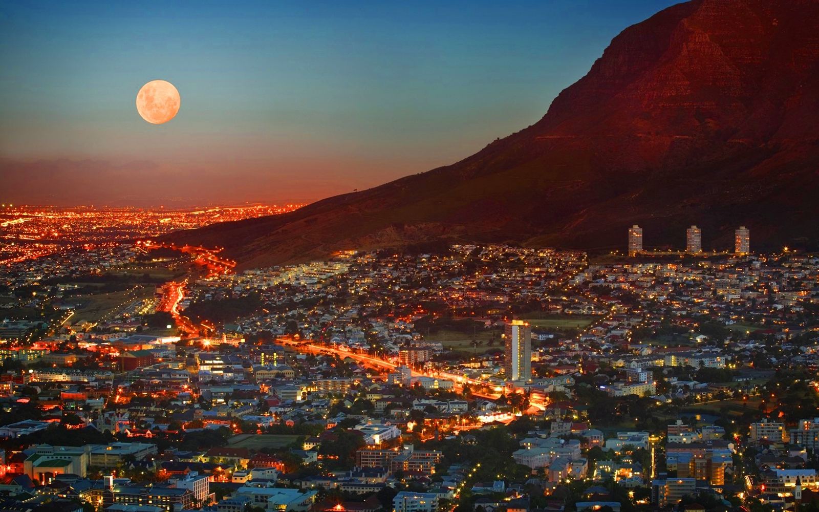 Cape Town lit up at dusk beneath the mountain