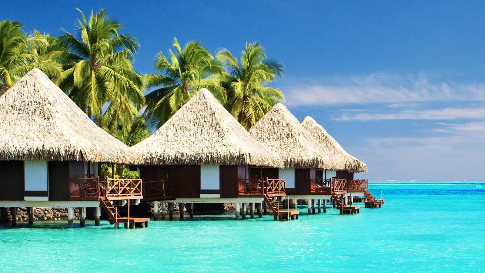 Overwater bungalows above a turquoise sea